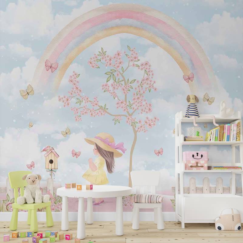 Papel de parede Maria Alice, com estampa fofa de arco íris, borboletas, uma árvores com flores rosa, uma pequena casa de passarinho perto de uma menina com chapéu. Toda a imagem é feita para dar o efeito de pintura em aquarela